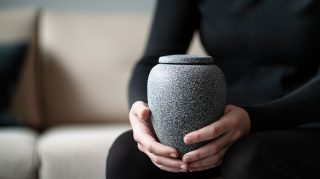 骨壺を持つ女性