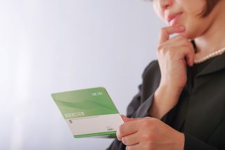 貯金通帳を見る女性